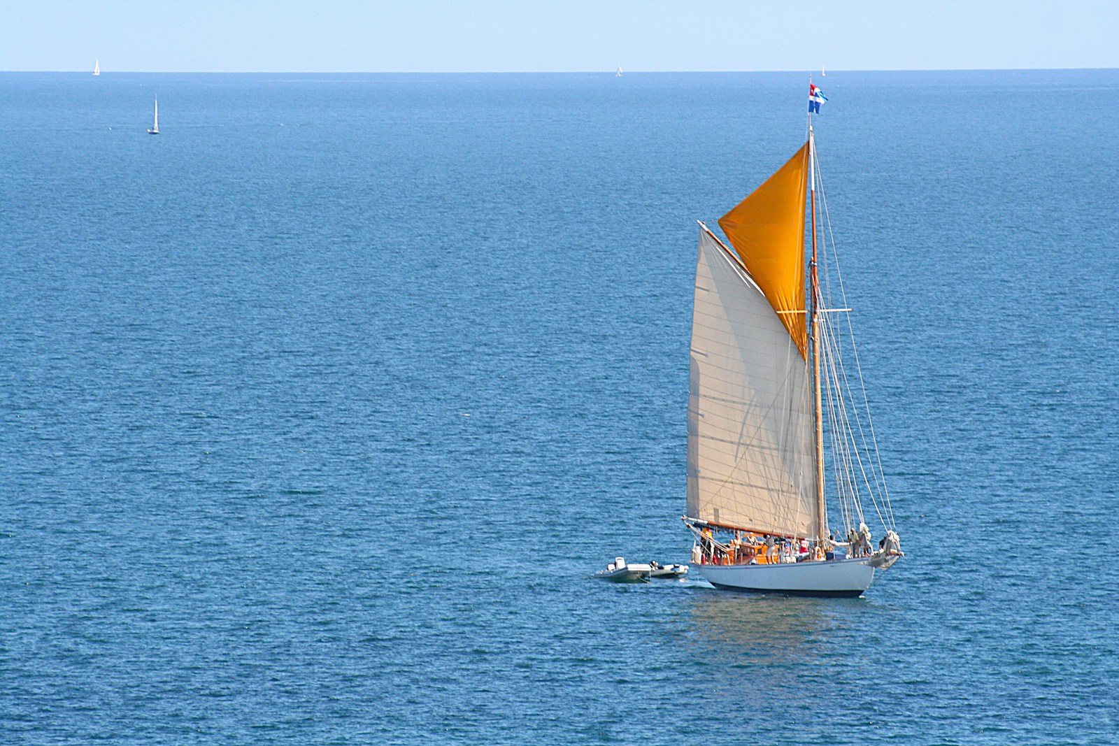 Sailboat with colorful sails glides across the ocean.