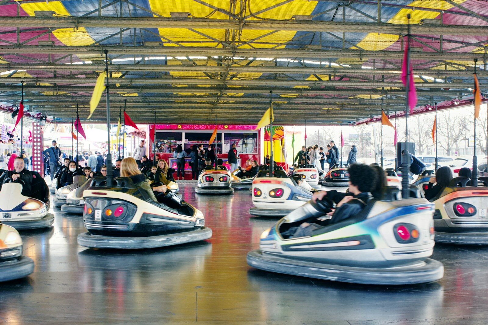 a group of people riding bumper cars inside of a building