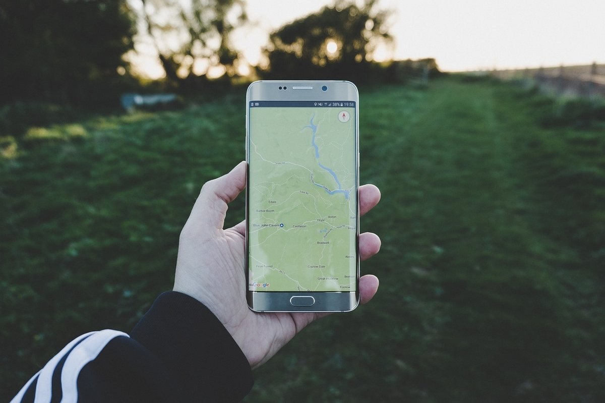 Main tenant un smartphone avec une carte