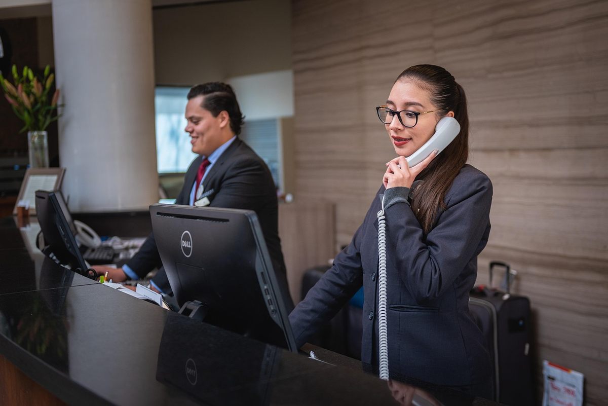 Deux agents d'hôtel, un homme et une femme, travaillent à la réception Deux agents d'hôtel, un homme et une femme, travaillent à la réception