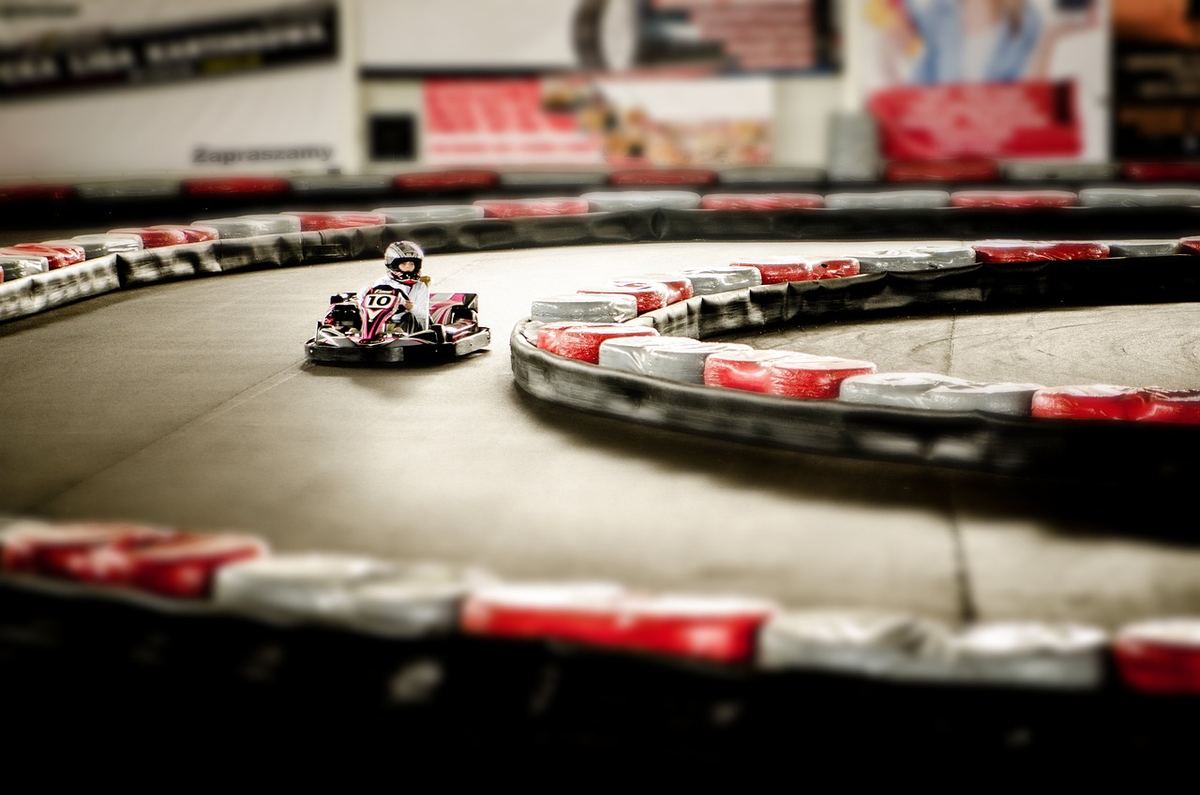 Un karting indoor avec un conducteur pilotant un kart sur une courbe