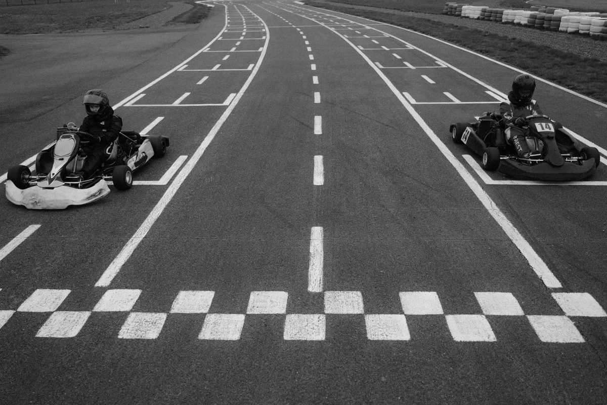 Deux kartingistes pilotent leurs kart à la ligne d'arrivée