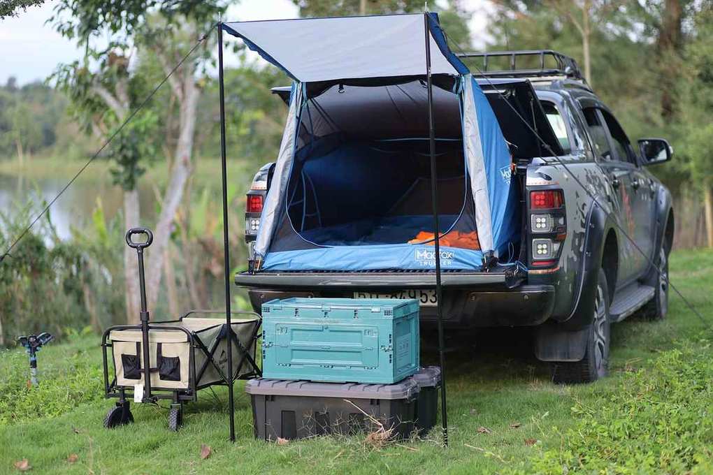 Camper-tente sur coffre d'un SUV, camping en bord de lac, objets de rangement, chariot à bagages