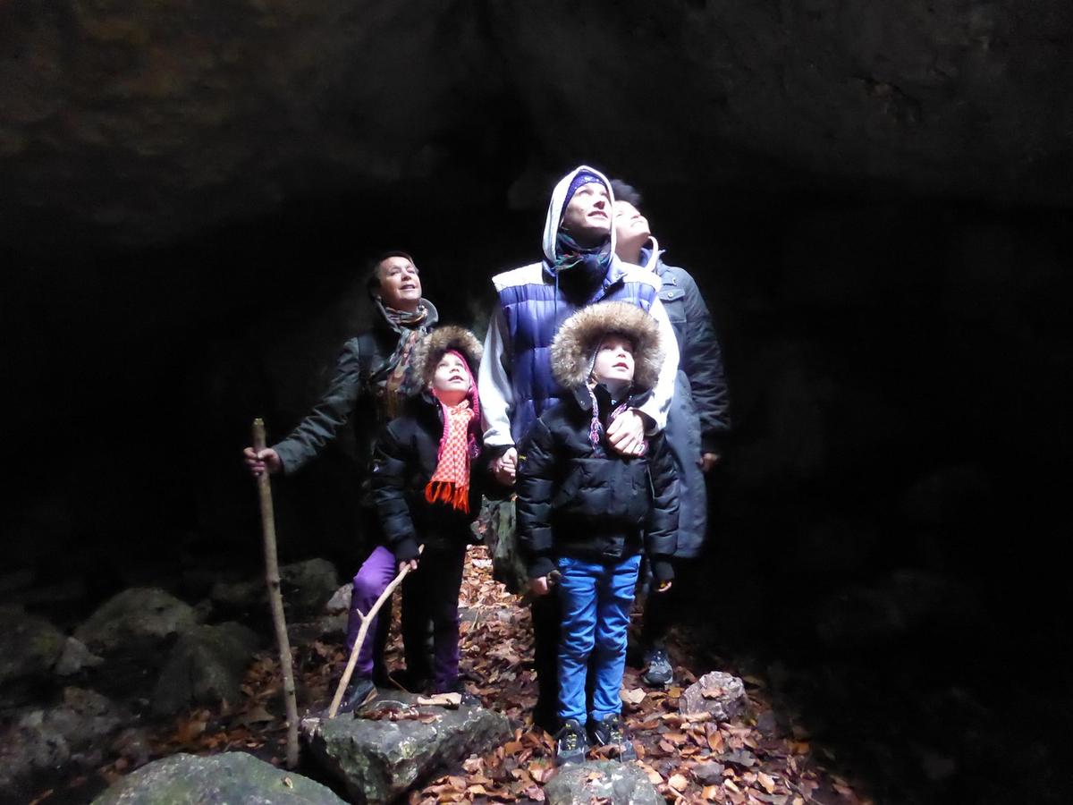 Quatre personnes, deux enfants, regardent le plafond de la grotte